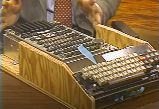 Apple I computer inside a wooden case with attached keyboard.