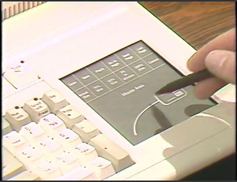 The Key-Tronic KB5153 keyboard, which has a built-in trackpad on the right side. There’s a hand holding a stylus and tapping the trackpad.