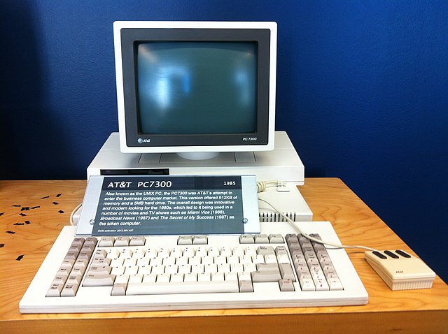 The AT&T PC 7300. A 1980s-style personal computer with a detached keyboard, a three-button mouse, and a small monitor on top of the main computer unit.